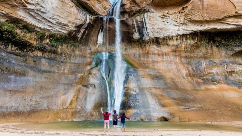 Hikers enjoy the cool mist rising off Lower Calf Creek Falls