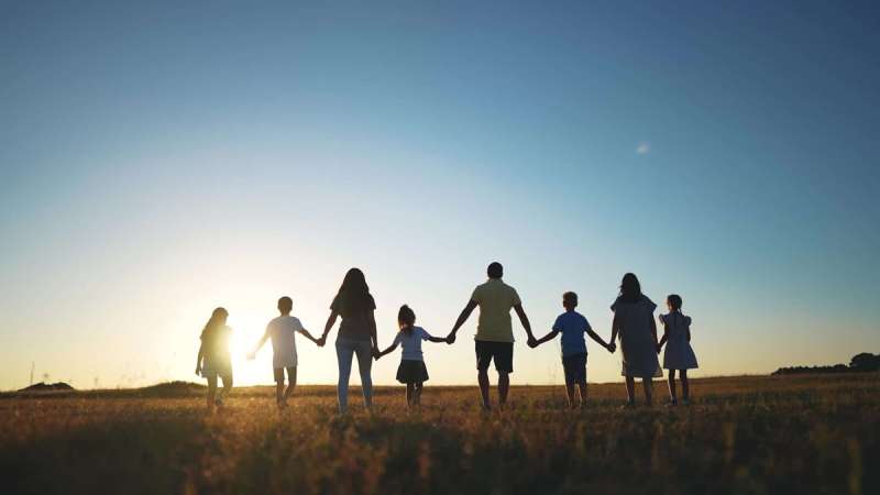 A family holding hands in an outdoor landscape